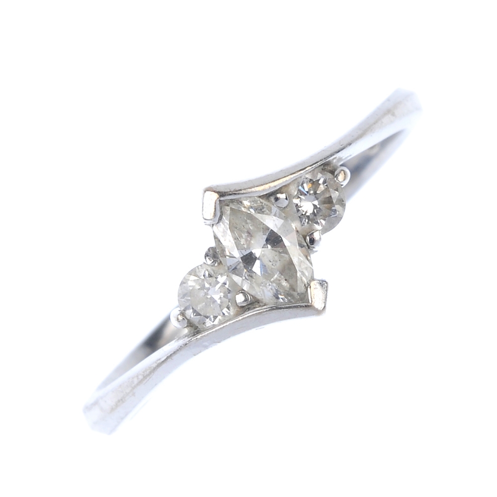 An 18ct gold diamond crossover ring. The marquise-shape diamond, with brilliant-cut diamond sides,