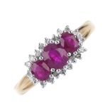 A 9ct gold ruby three-stone and diamond cluster ring. The slightly graduated oval-shape ruby line,