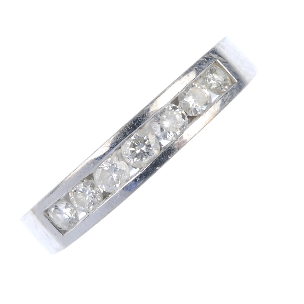 An 18ct gold diamond half-circle eternity ring. The brilliant-cut diamond line, inset to the plain