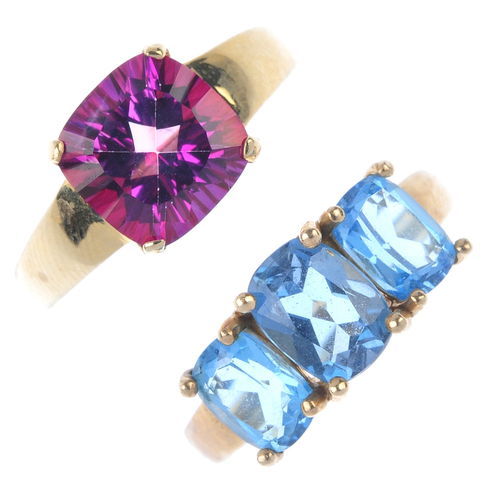 A selection of four 9ct gold gem-set rings. To include a blue topaz three-stone ring, a garnet