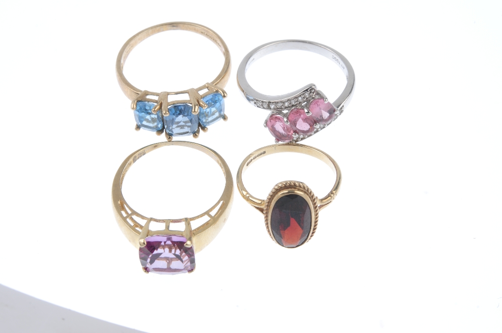 A selection of four 9ct gold gem-set rings. To include a blue topaz three-stone ring, a garnet - Image 2 of 3