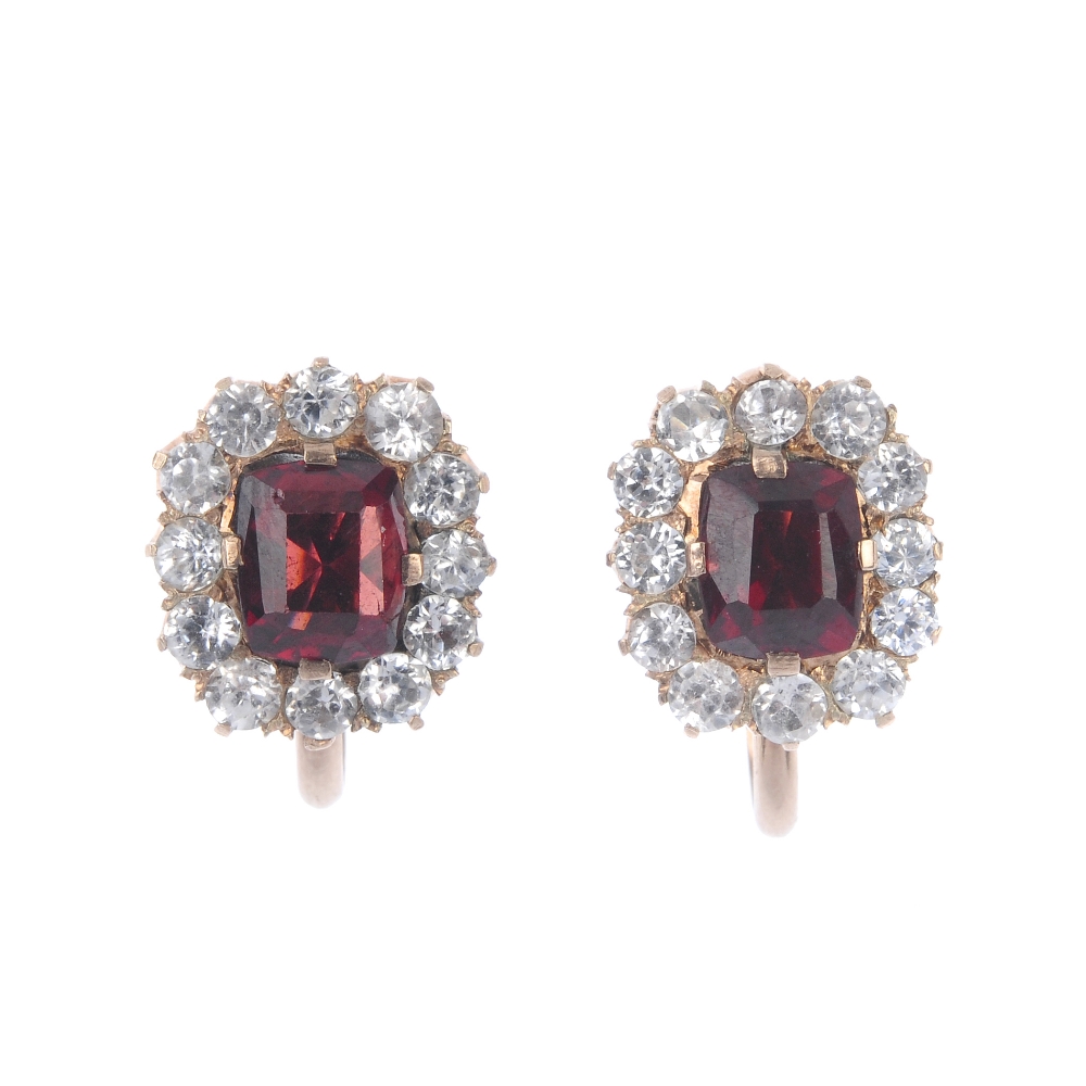 A pair of garnet and paste cluster ear clips. The rectangular-shape garnet, within a circular-