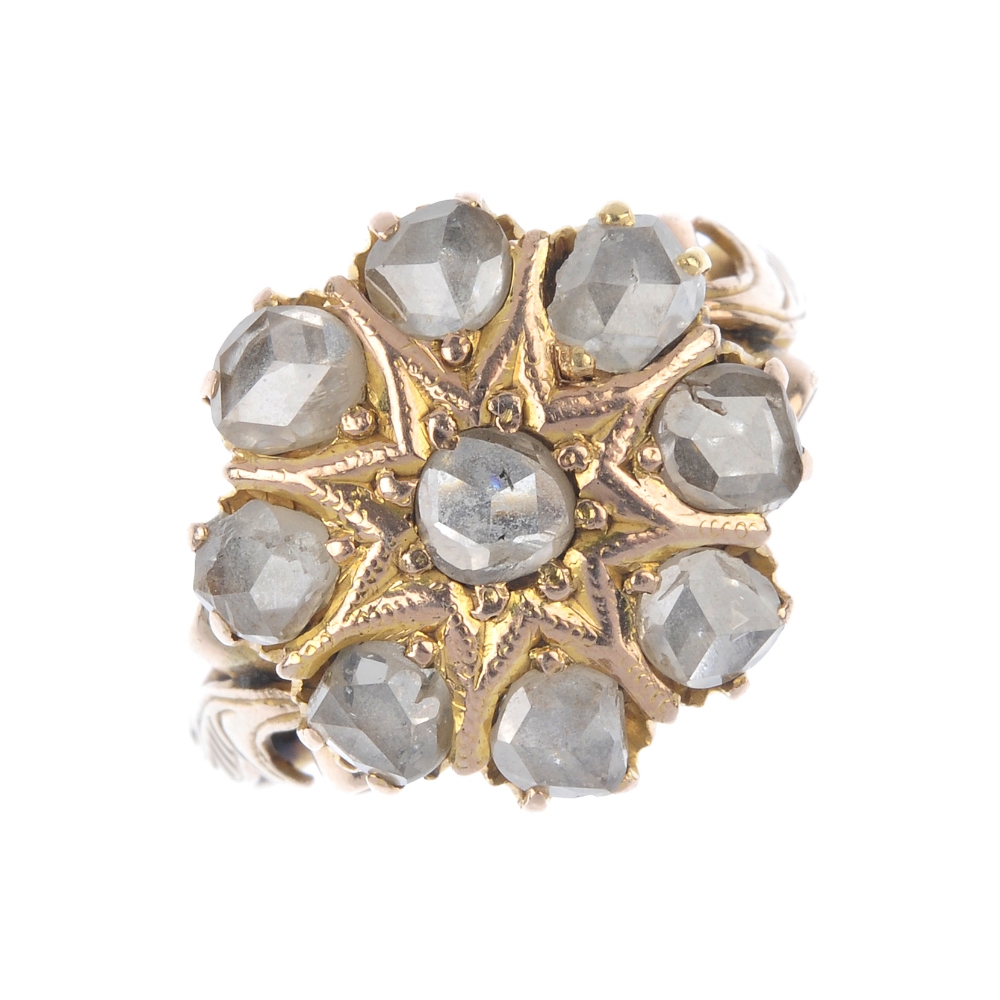 An 18ct gold diamond cluster ring. The rose-cut diamond star, within a similarly-cut diamond