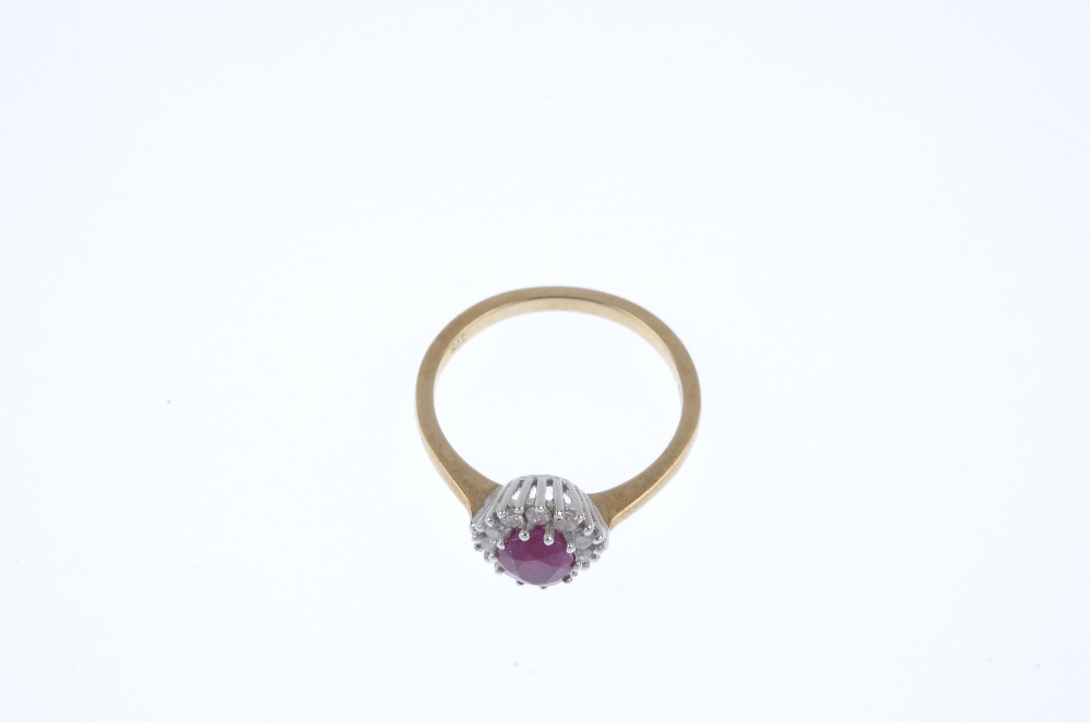 A 9ct gold ruby and diamond cluster ring. The oval-shape ruby, within a brilliant-cut diamond - Image 2 of 4