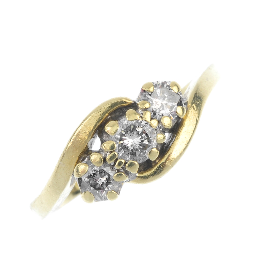 An 18ct gold diamond crossover ring. The graduated brilliant-cut diamond line, to the asymmetric
