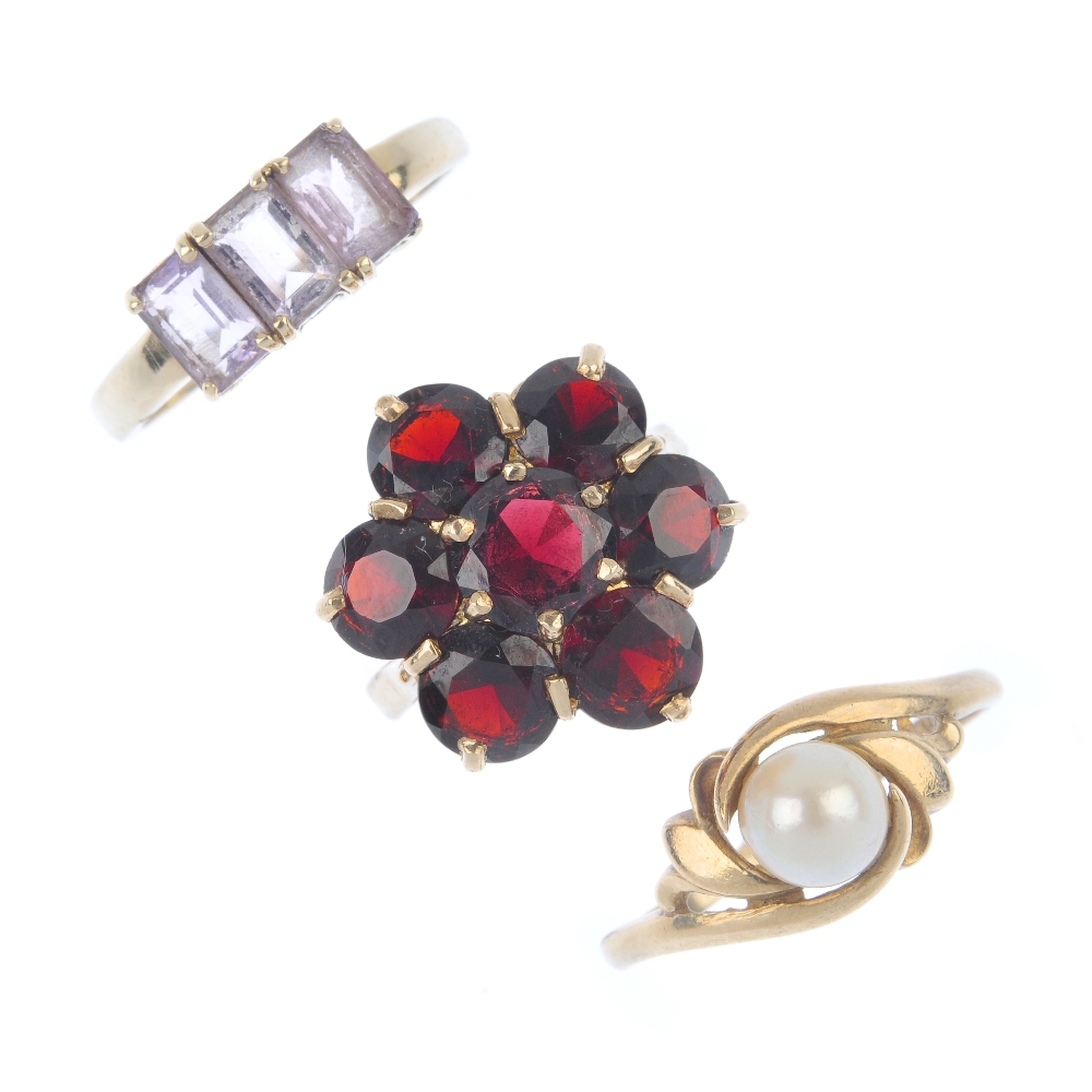 A selection of three 9ct gold gem-set rings. To include a garnet cluster ring, an amethyst three-