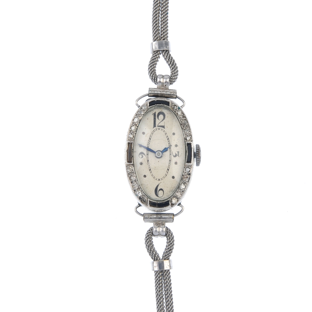 A lady's mid 20th century diamond and onyx manual wind cocktail watch. The oval-shape cream dial and