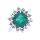 * An 18ct gold emerald and diamond cluster ring. The square-shape emerald, within a brilliant-cut