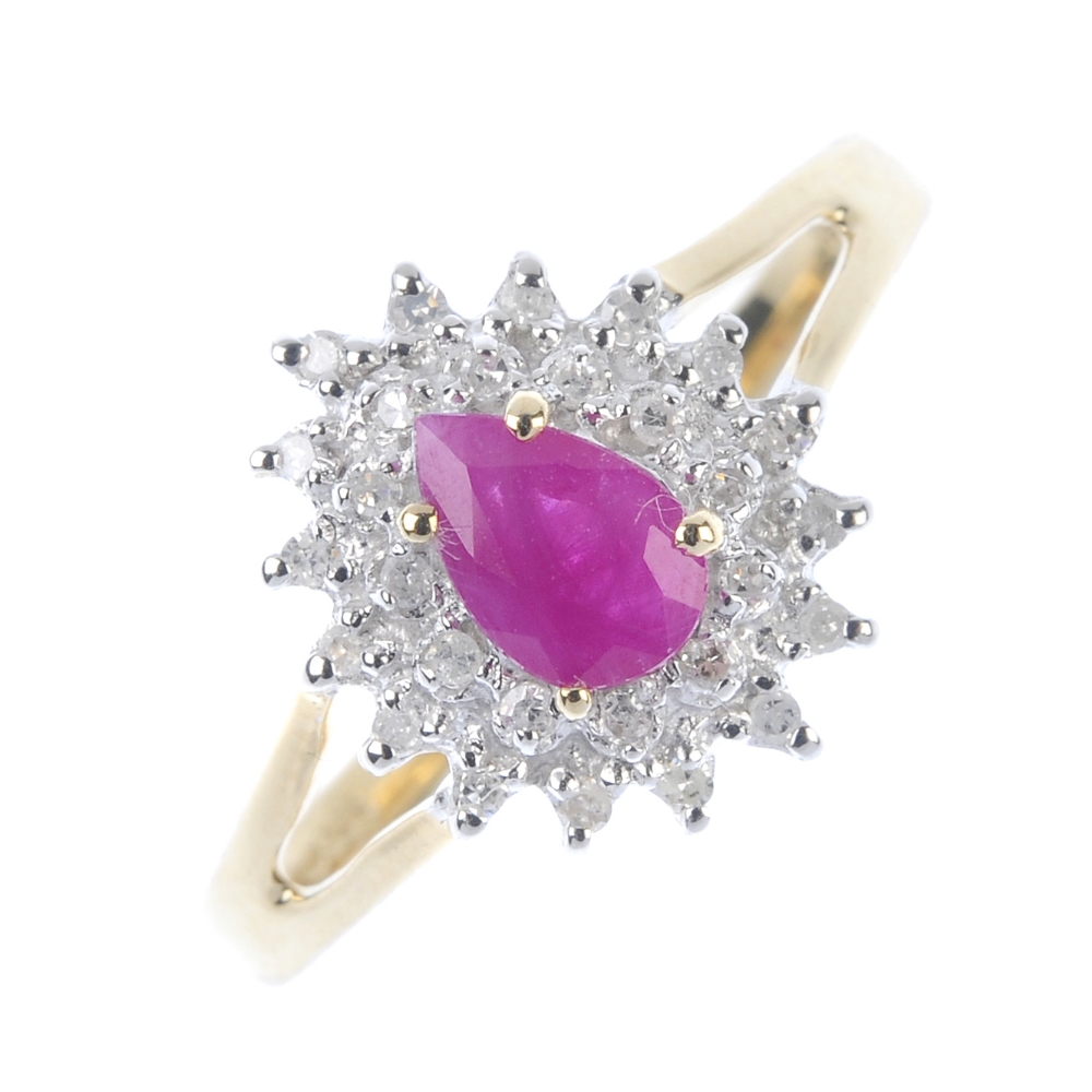 A 9ct gold ruby and diamond cluster ring. The pear-shape ruby, within a single-cut diamond double