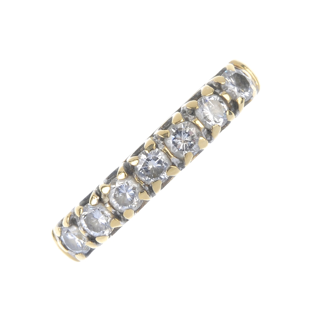 An 18ct gold diamond seven-stone ring. The brilliant-cut diamond line, to the tapered band. Total