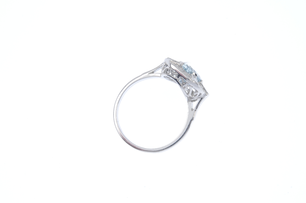 An aquamarine and diamond dress ring. The oval-shape aquamarine, within a single and baguette-cut - Image 4 of 4