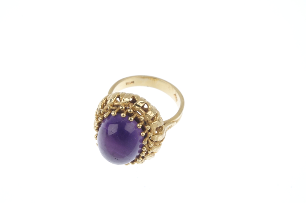 An amethyst single-stone ring. The oval amethyst cabochon, within a bead surround, to the openwork - Image 2 of 4