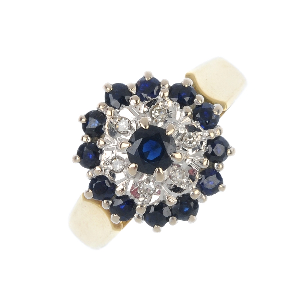 An 18ct gold sapphire and diamond cluster ring. The circular-shape sapphire, raised to the single-