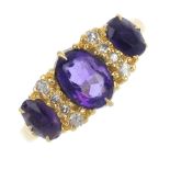 An 18ct gold amethyst three-stone and diamond dress ring. The graduated oval-shape amethyst line,