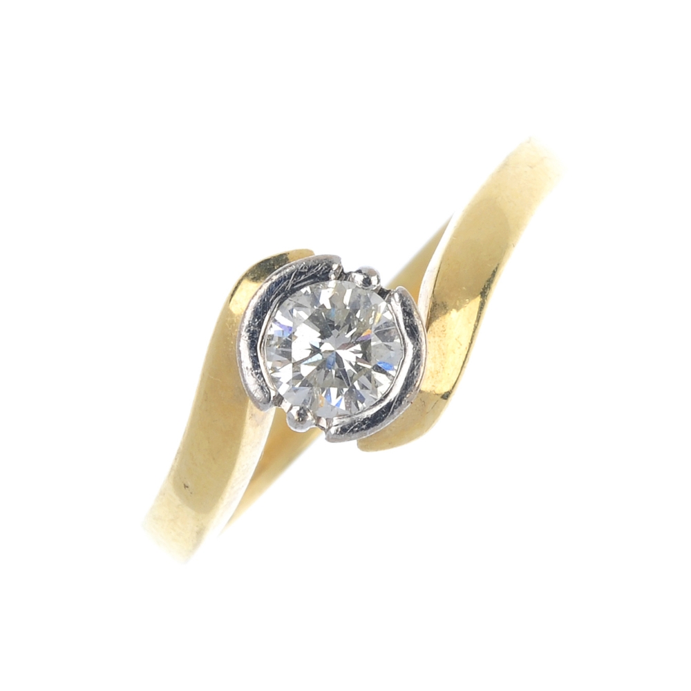 An 18ct gold diamond single-stone ring. The brilliant-cut diamond partial collet, to the crossover