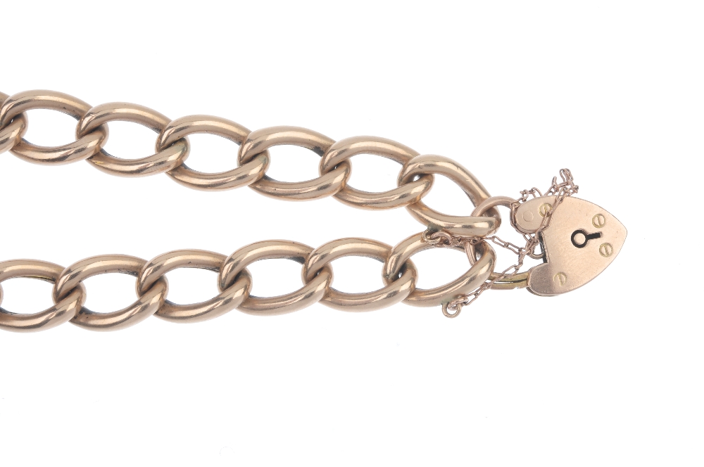 An Edwardian 9ct gold curb-link bracelet. The elongated curb-links, to the padlock clasp. Clasp with - Image 2 of 3