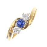 An 18ct gold sapphire and diamond crossover ring. The circular-shape sapphire, with brilliant-cut