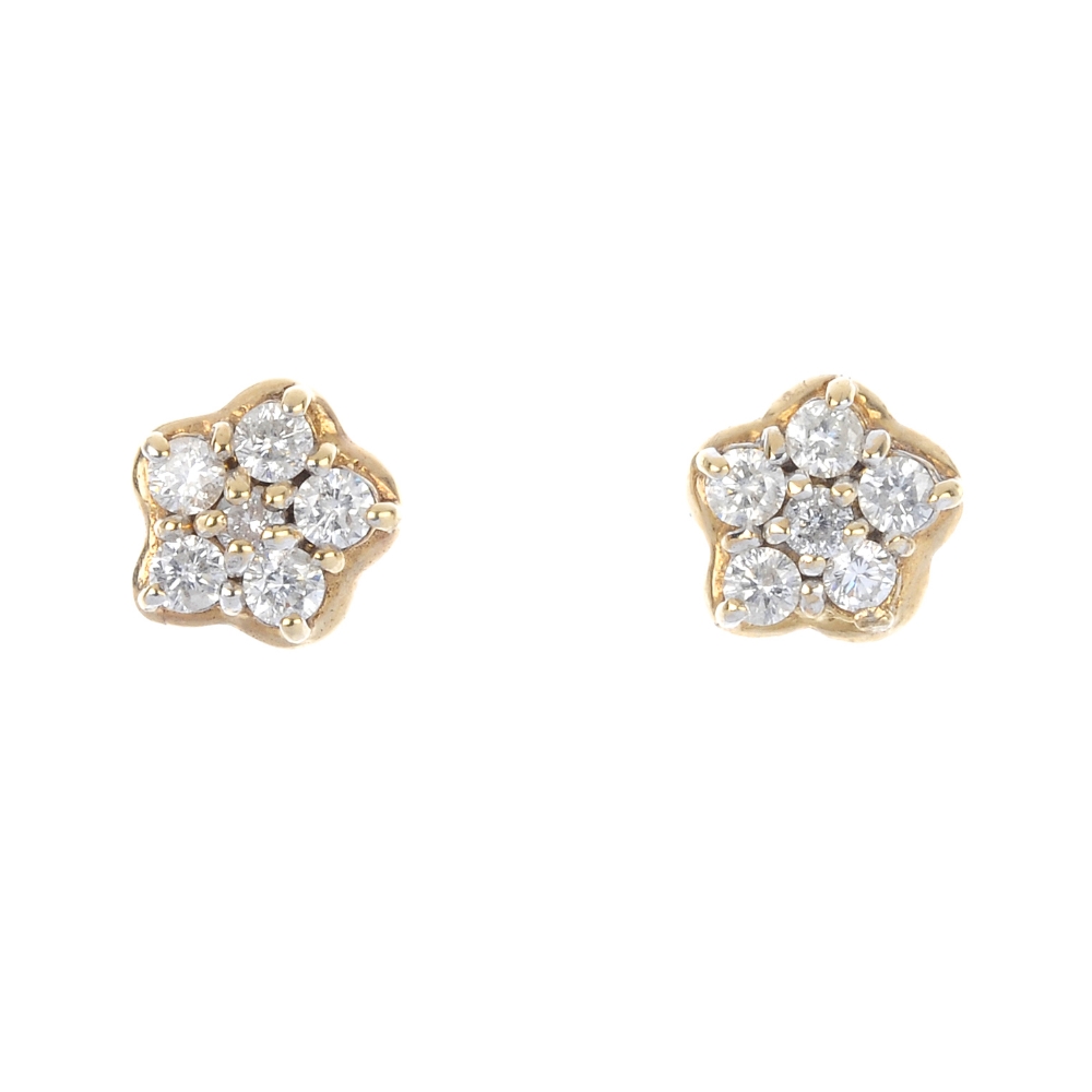 A pair of 9ct gold diamond cluster ear studs. Each designed as a brilliant-cut diamond, within a