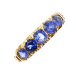 An early 20th century 18ct gold gem-set five-stone ring. The graduated circular-shape sapphire and