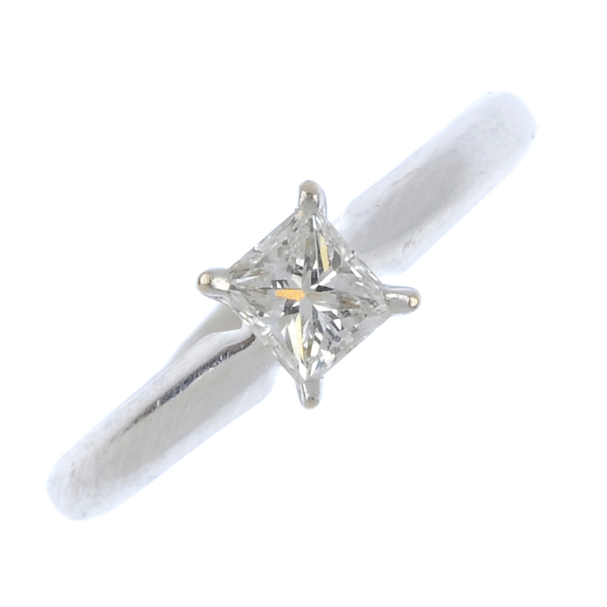 A diamond single-stone ring. The rectangular-shape diamond, weighing 0.33ct, to the plain band.
