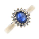 A 9ct gold sapphire and diamond cluster ring. The oval-shape sapphire, within a single-cut diamond