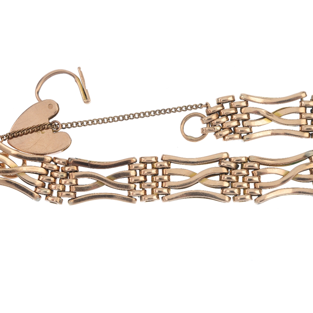 An early 20th century 9ct gold gate bracelet. Designed as a series of crossover bar gate-links, to