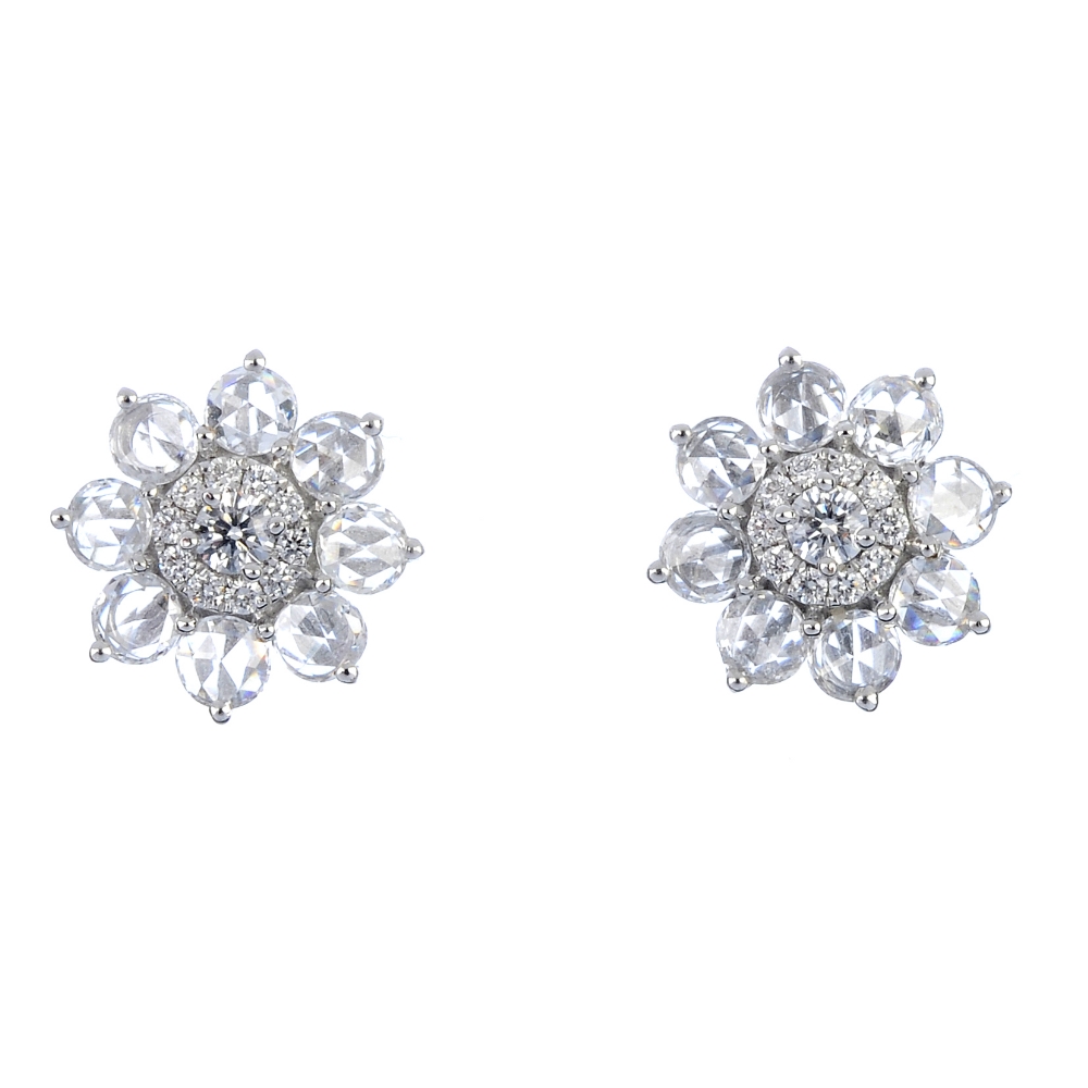 * A pair of diamond floral cluster ear studs. Each designed as a brilliant-cut diamond cluster,