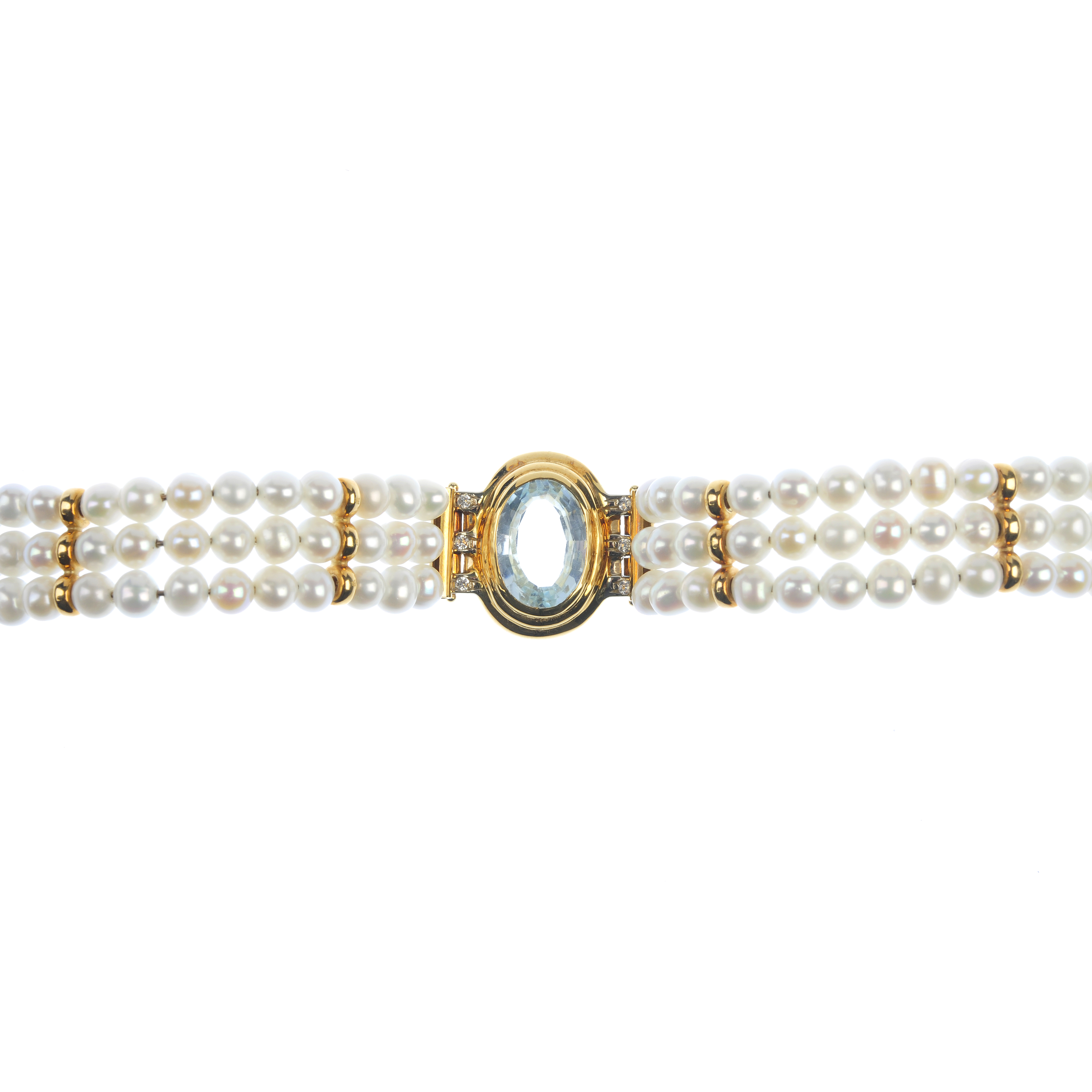 A topaz, diamond and cultured pearl bracelet. The oval-shape blue topaz, within a grooved surround