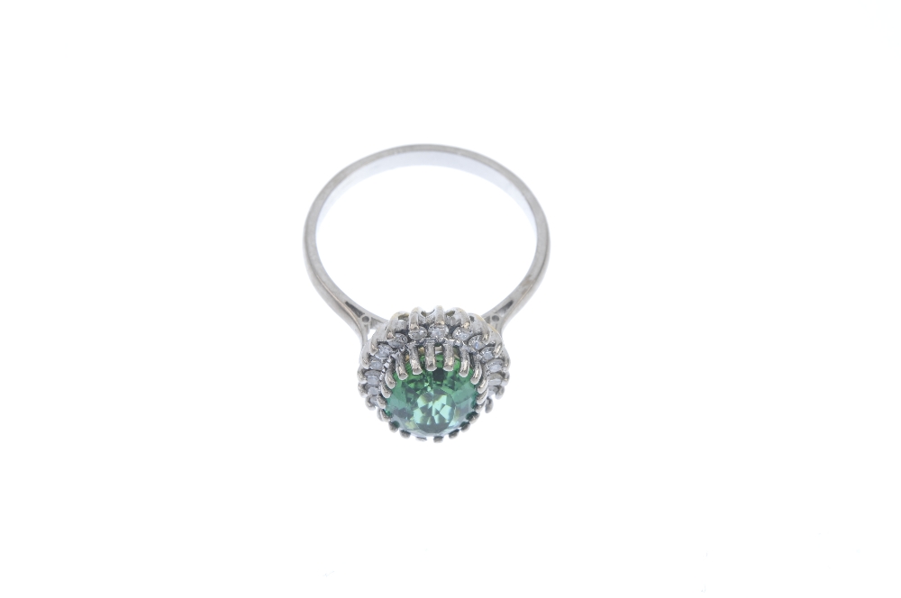 A tourmaline and diamond cluster ring. The oval-shape green tourmaline, within a single-cut - Image 2 of 3