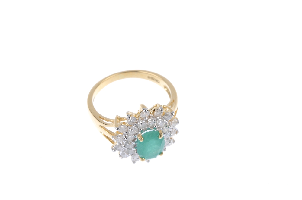 An 18ct gold emerald and diamond cluster ring. The oval-shape emerald, within a brilliant-cut - Image 2 of 4