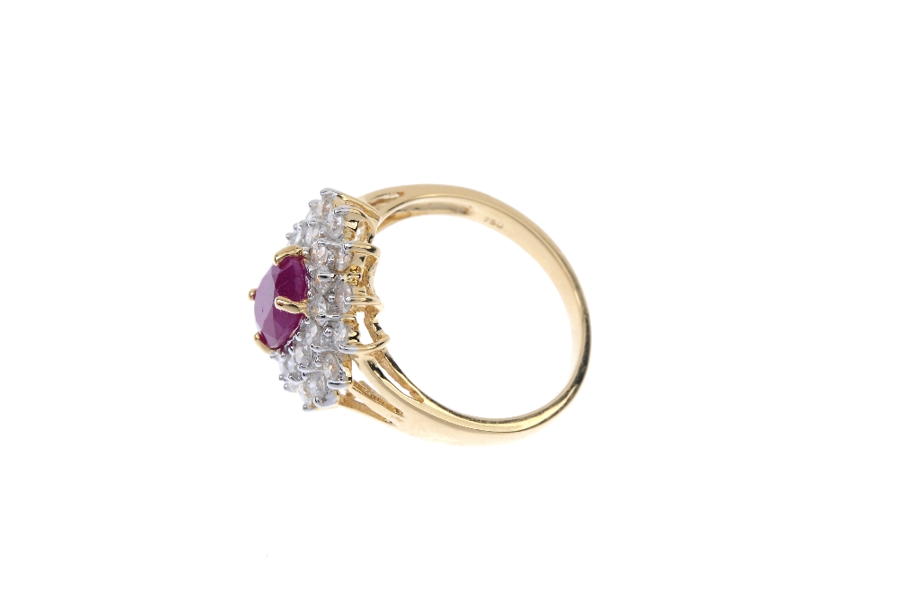 An 18ct gold ruby and diamond cluster ring. The oval-shape ruby, within a brilliant-cut diamond - Image 3 of 4