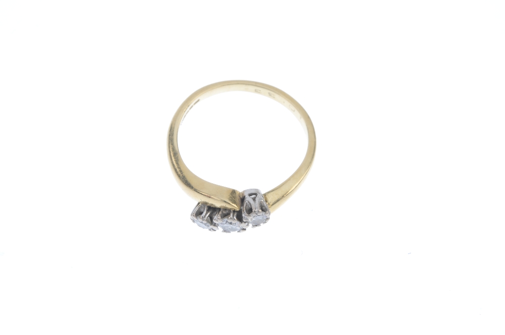 An 18ct gold diamond three-stone ring. The graduated brilliant-cut diamond diagonal line, to the - Image 2 of 3