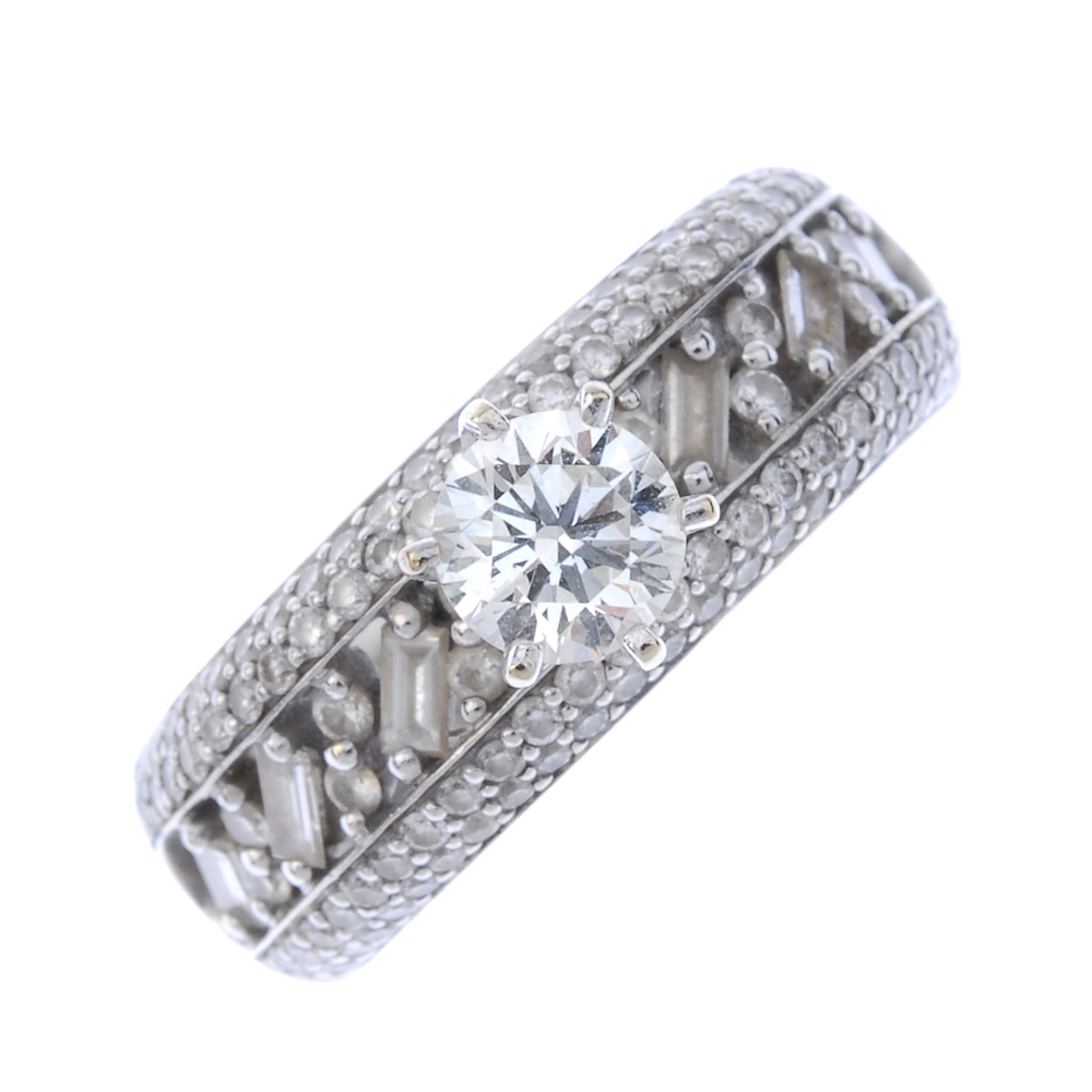 A diamond dress ring. The brilliant-cut diamond, set atop a brilliant and baguette-cut diamond