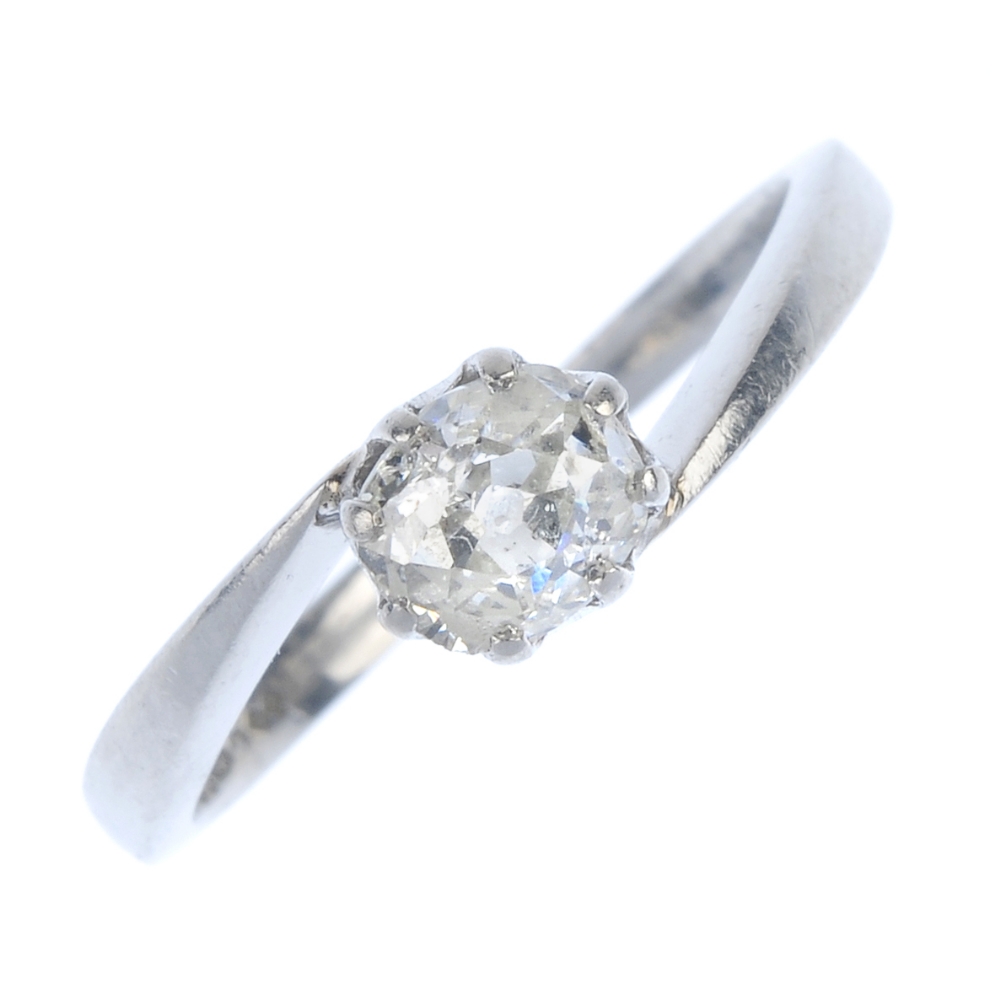 A platinum diamond single-stone ring. The old-cut diamond, to the asymmetric shoulders and plain