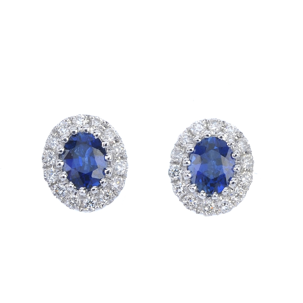 * A pair of sapphire and diamond cluster ear studs. Each designed as an oval-shape sapphire,