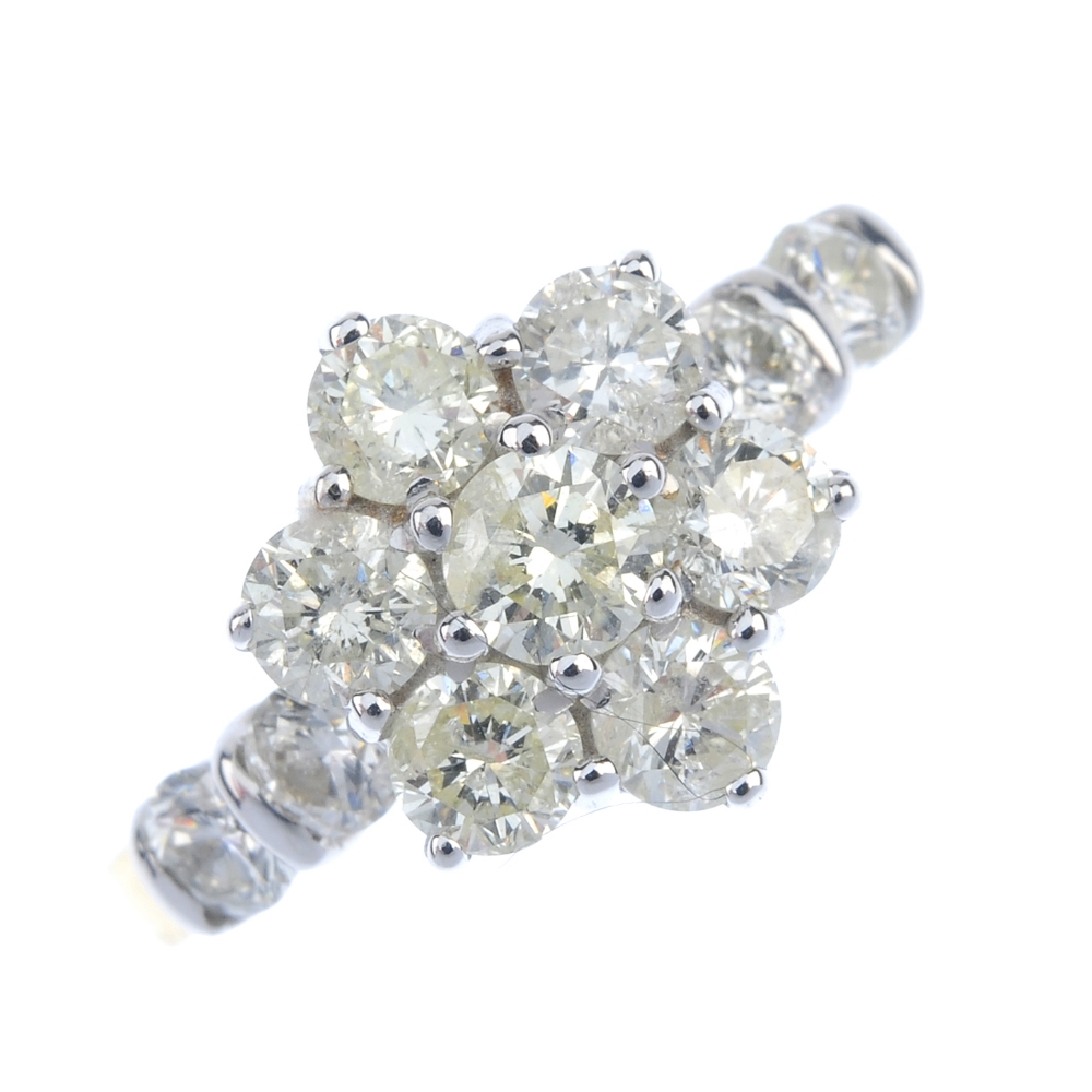 An 18ct gold diamond cluster ring. The brilliant-cut diamond floral cluster, to the similarly-cut