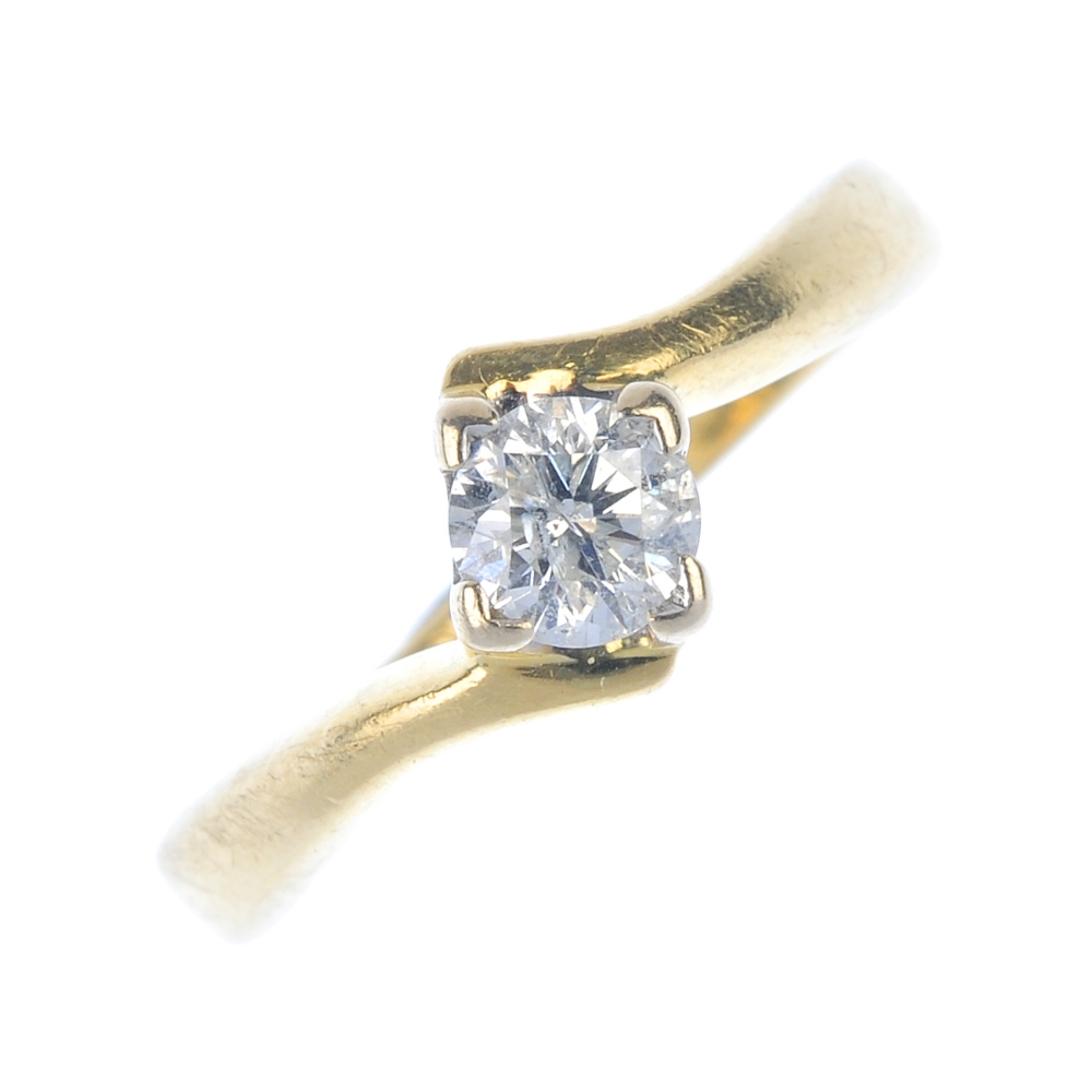 An 18ct gold diamond single-stone ring. The brilliant-cut diamond, to the asymmetric shoulders.