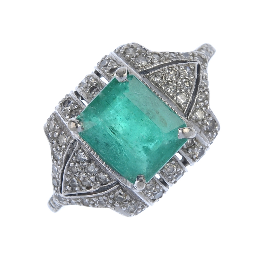 An emerald and diamond dress ring. The rectangular-shape emerald, within a pave-set diamond