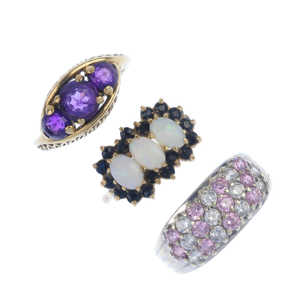 A selection of three gem-set dress rings. To include an amethyst three-stone ring, a 9ct gold oval