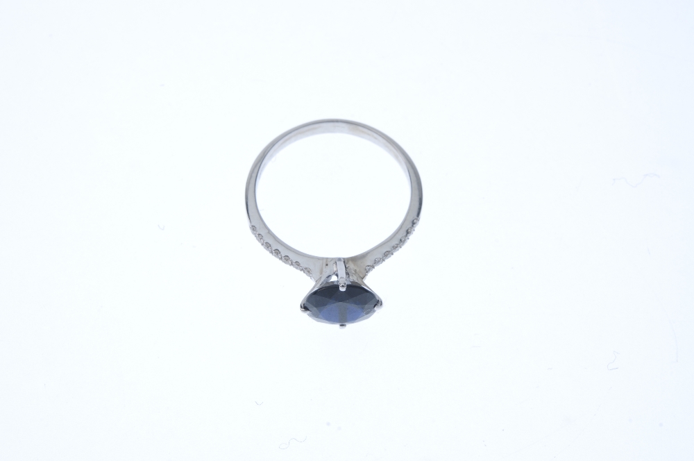 A sapphire and diamond ring. The circular-shape sapphire, to the brilliant-cut diamond line sides - Image 2 of 3