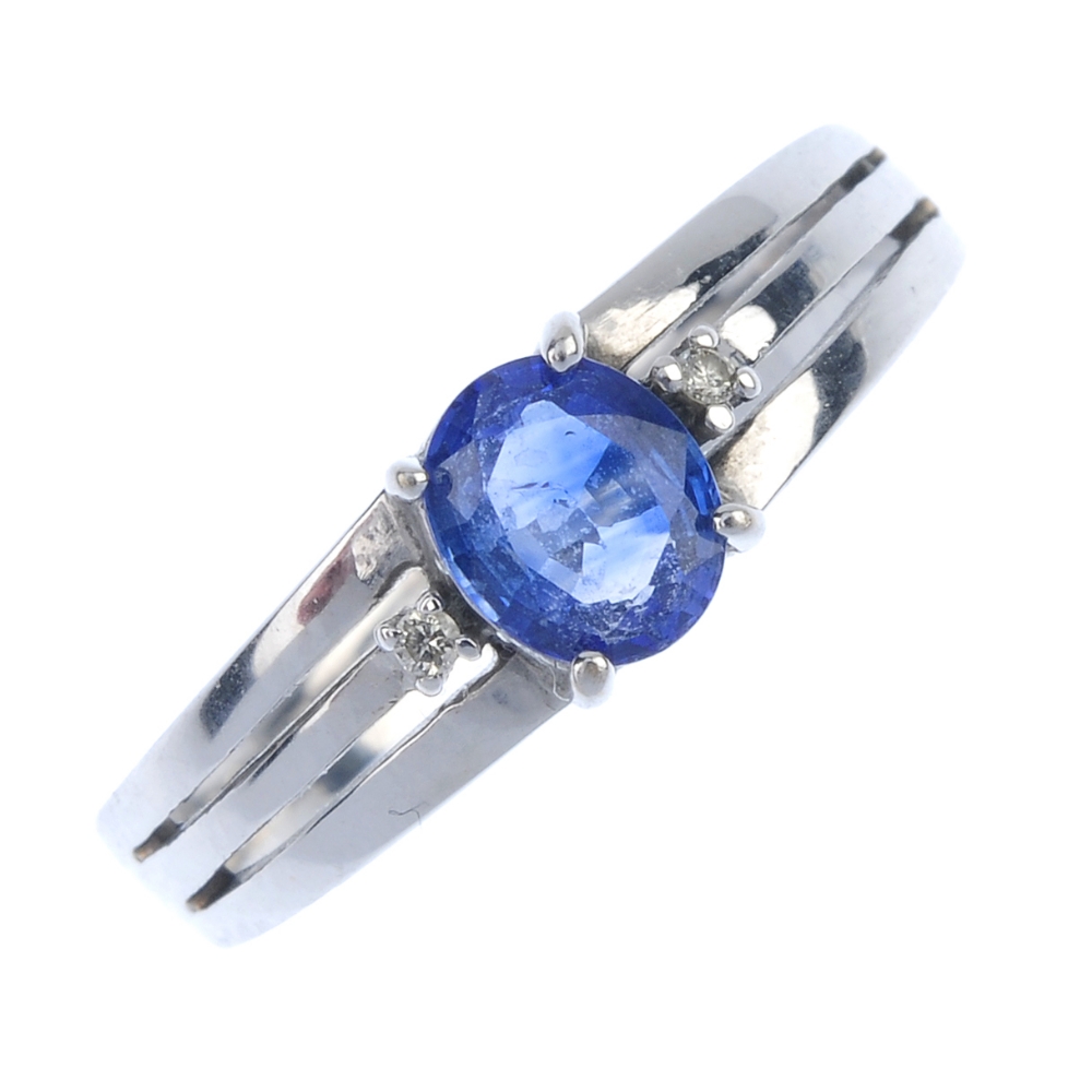 A sapphire and diamond three-stone ring. The oval-shape sapphire, with brilliant-cut diamond