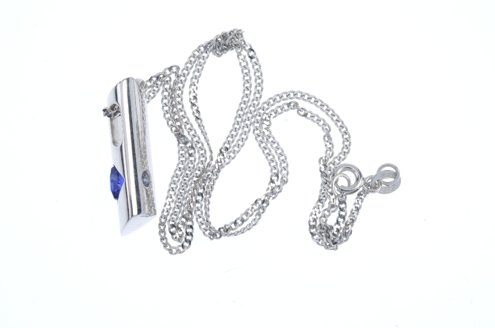 A sapphire and diamond pendant. The cushion-shape sapphire, inset to the tapered bar, with - Image 2 of 2