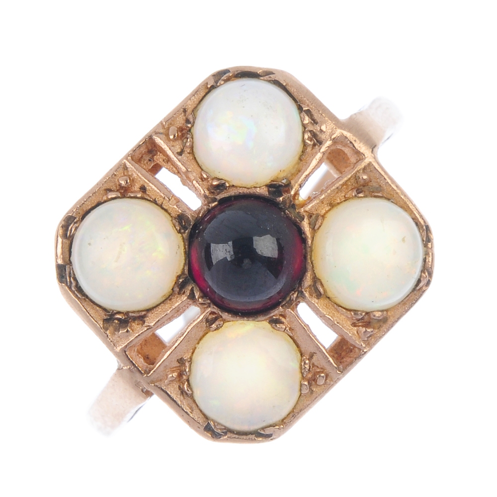 Two 9ct gold gem-set rings. The first designed as a circular garnet cabochon within a circular