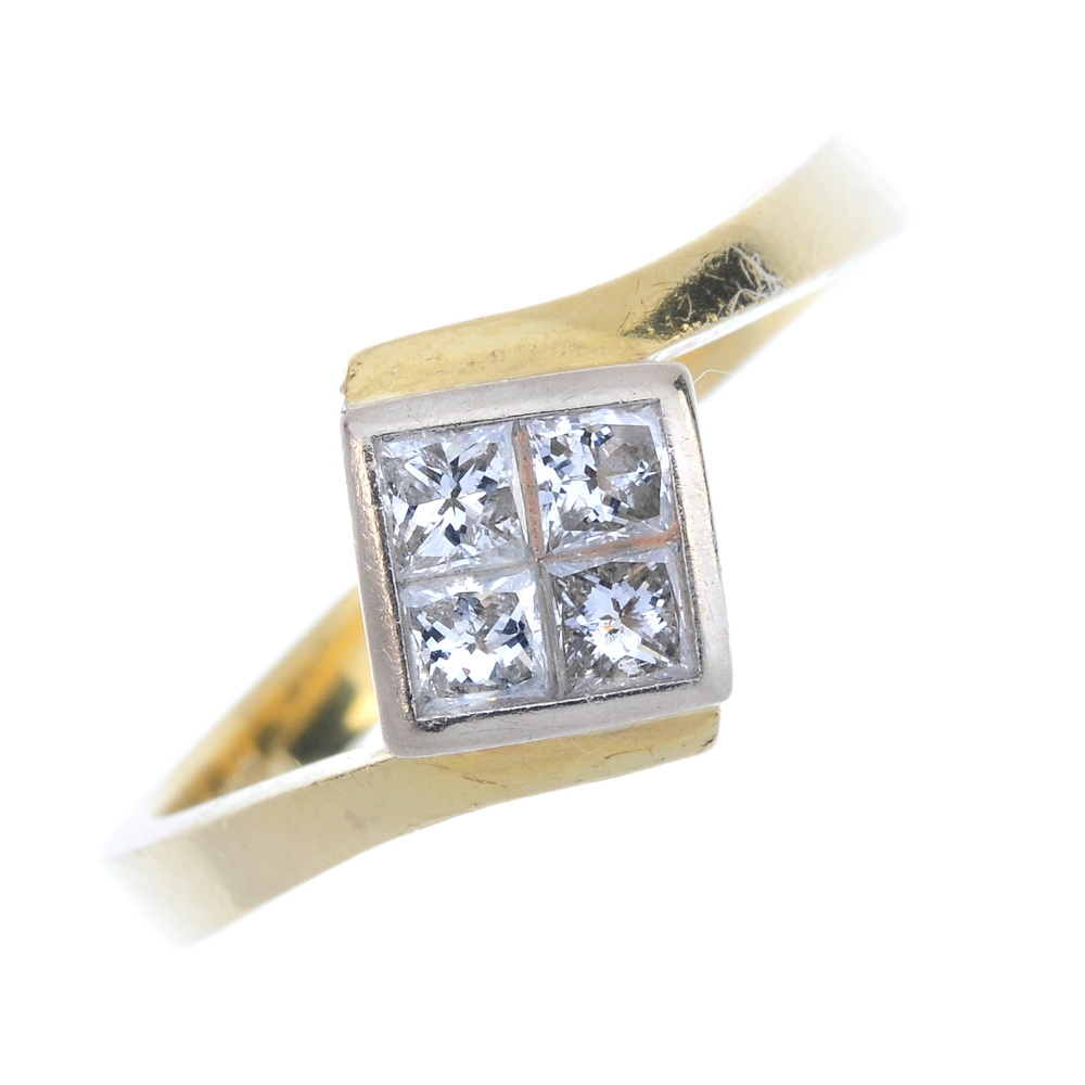 An 18ct gold diamond four-stone ring. The square-shape diamond panel, with crossover shoulders and