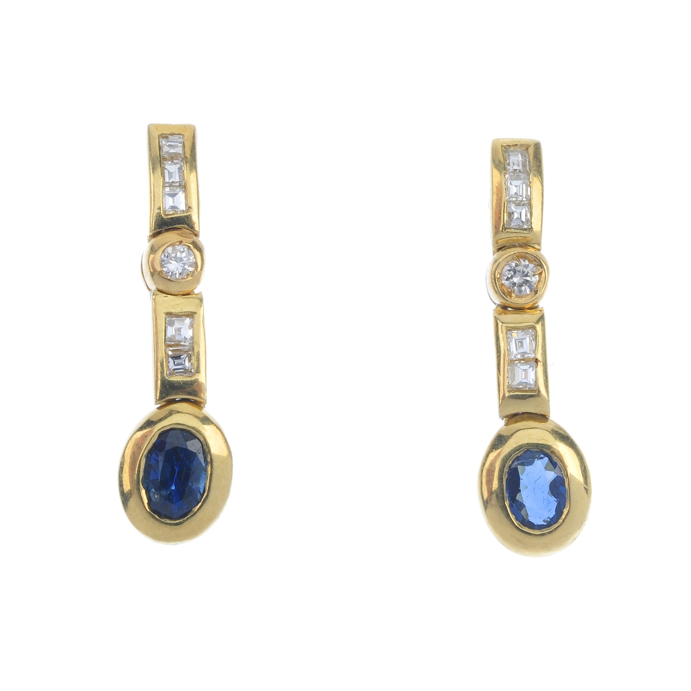 A pair of sapphire and diamond ear pendants. Each designed as an oval-shape sapphire collets,