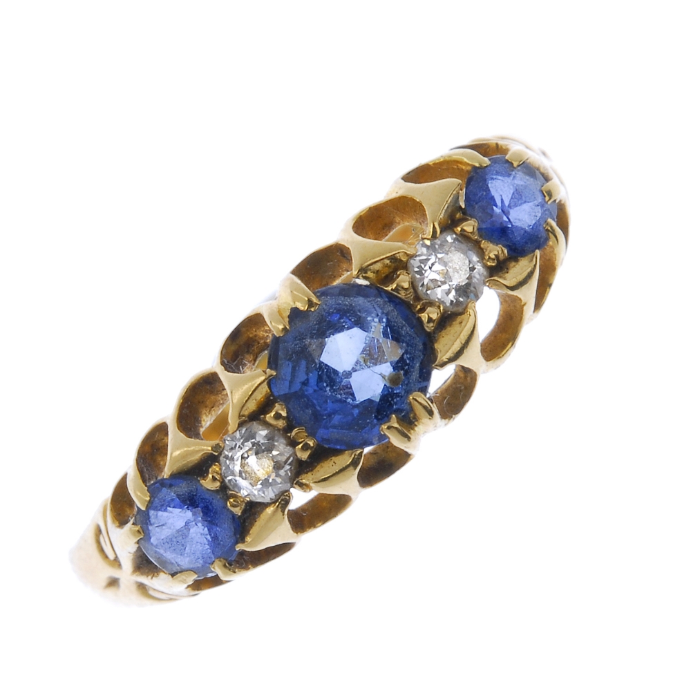 An Edwardian 18ct gold sapphire and diamond ring. The circular-shape sapphire and brilliant-cut