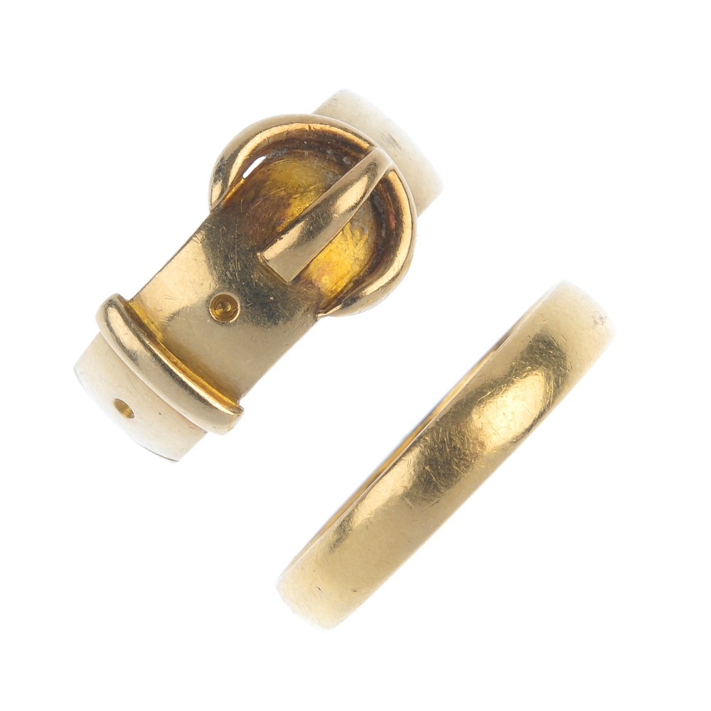 Two early 20th century gold rings. To include an Edwardian 18ct gold belt motif ring, together