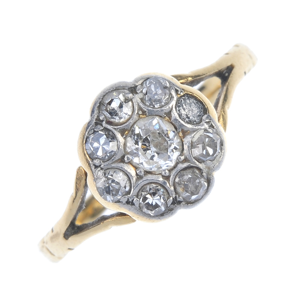 A mid 20th century 18ct gold diamond cluster ring. The old-cut diamond, within a single-cut