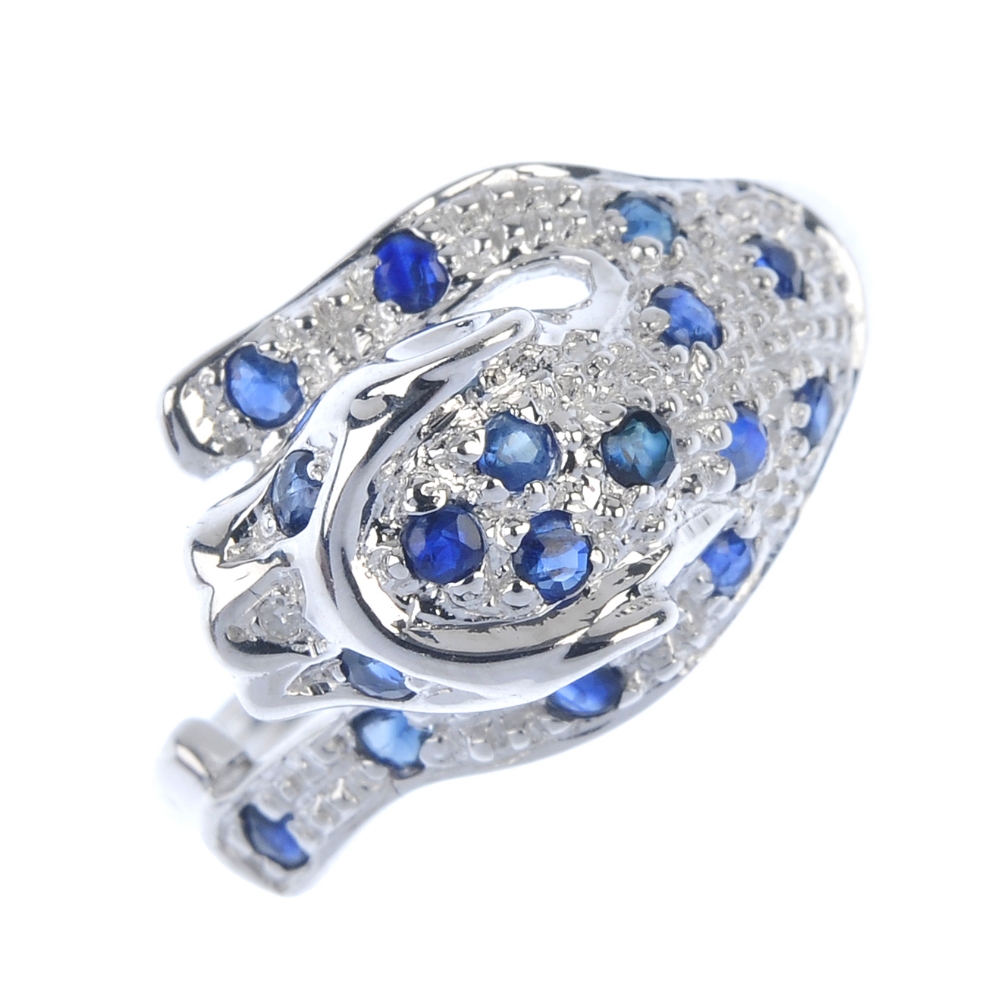 A 9ct gold sapphire and diamond leopard ring. Set with circular-shape sapphire and a single-cut