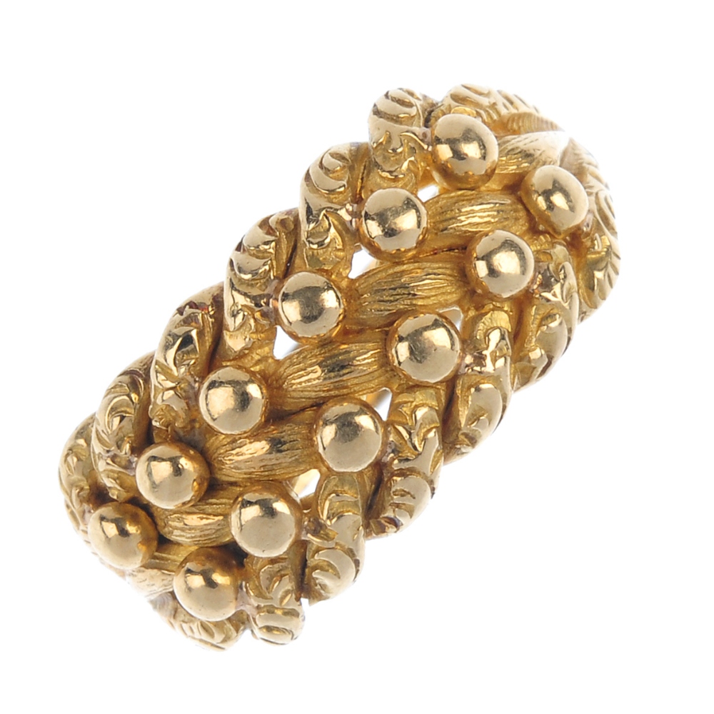 An Edwardian 18ct gold keeper ring. The bead highlight and vari-texture interwoven panel, to the